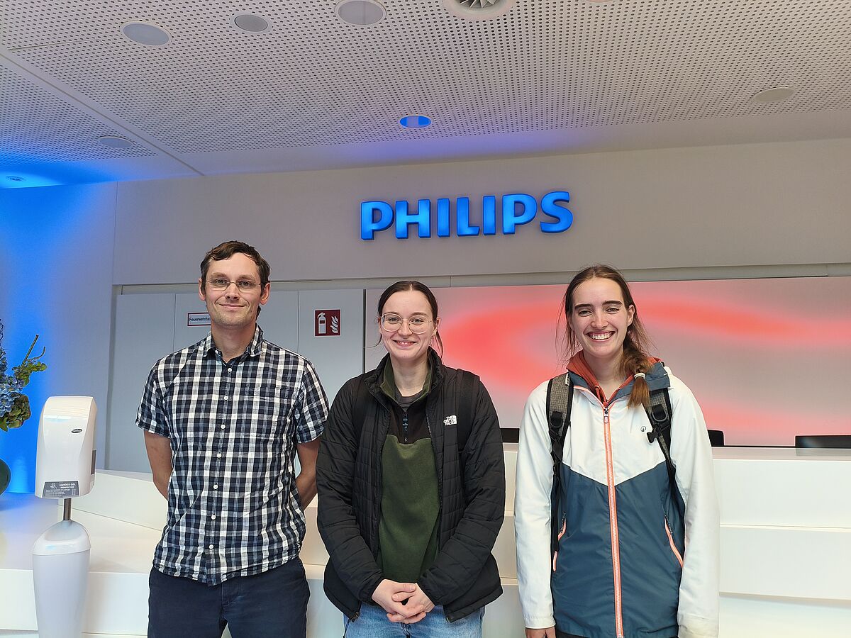 Teilnehmenden der Exkursion aus Greifswald vor dem Philips-Logo am Standort Hamburg